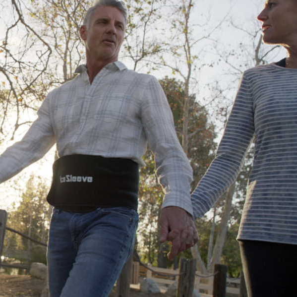 man walking in park wearing lower back icesleeve